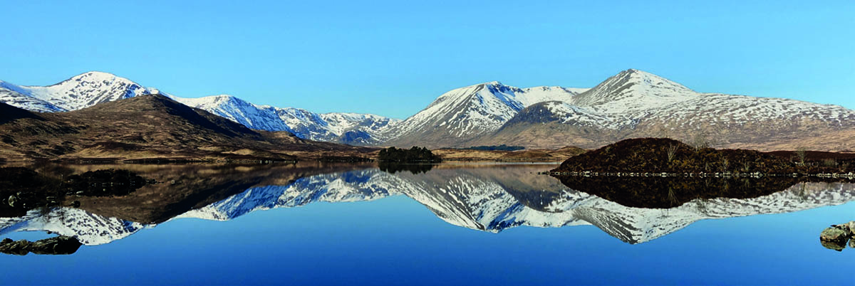 Winter landscape of Glencoe with snow-covered mountains and surrounding wilderness.
