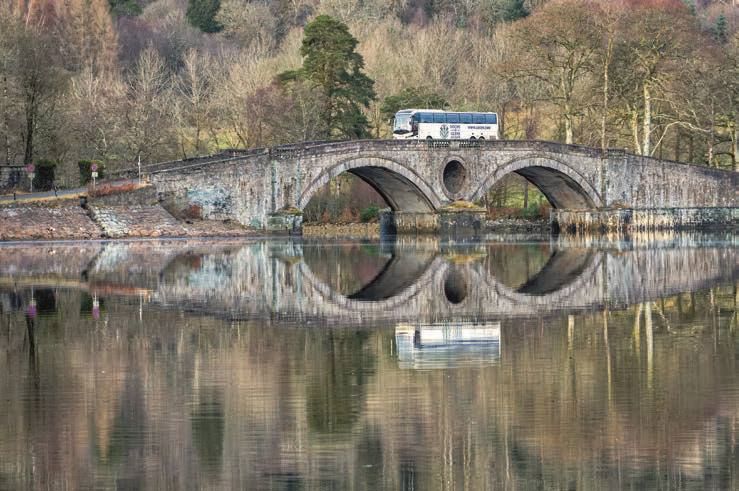 Serene image and perfect timing of Lochs and Glens coach going over bridge at Inverarary