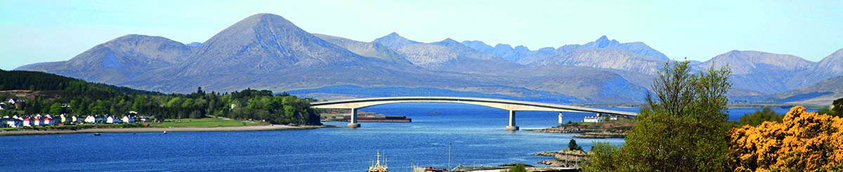 The Skye Bridge spanning over the sea, connecting the Isle of Skye to the Scottish mainland, with its elegant arch and scenic coastal backdrop.